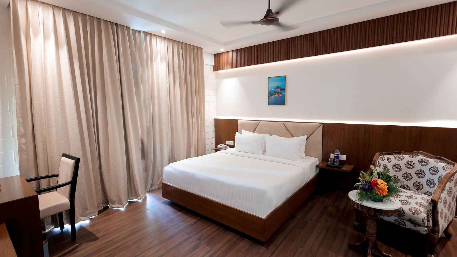 Room with modern interiors, ceiling fan, and warm lighting at Trishvam Symphony, Krishnagiri.