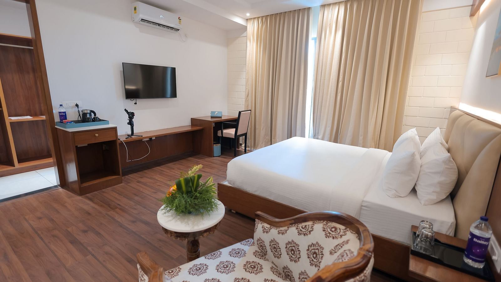 Room with modern interiors, ceiling fan, and warm lighting at Trishvam Symphony, Krishnagiri.