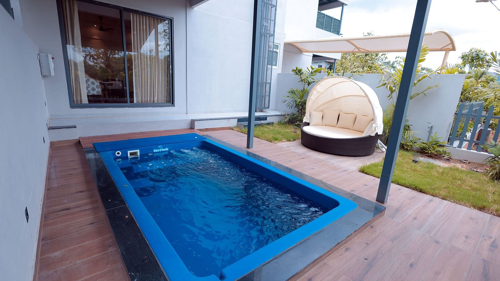 View of poolside with round canopy seating in villa courtyard at Trishvam Symphony, Krishnagiri.