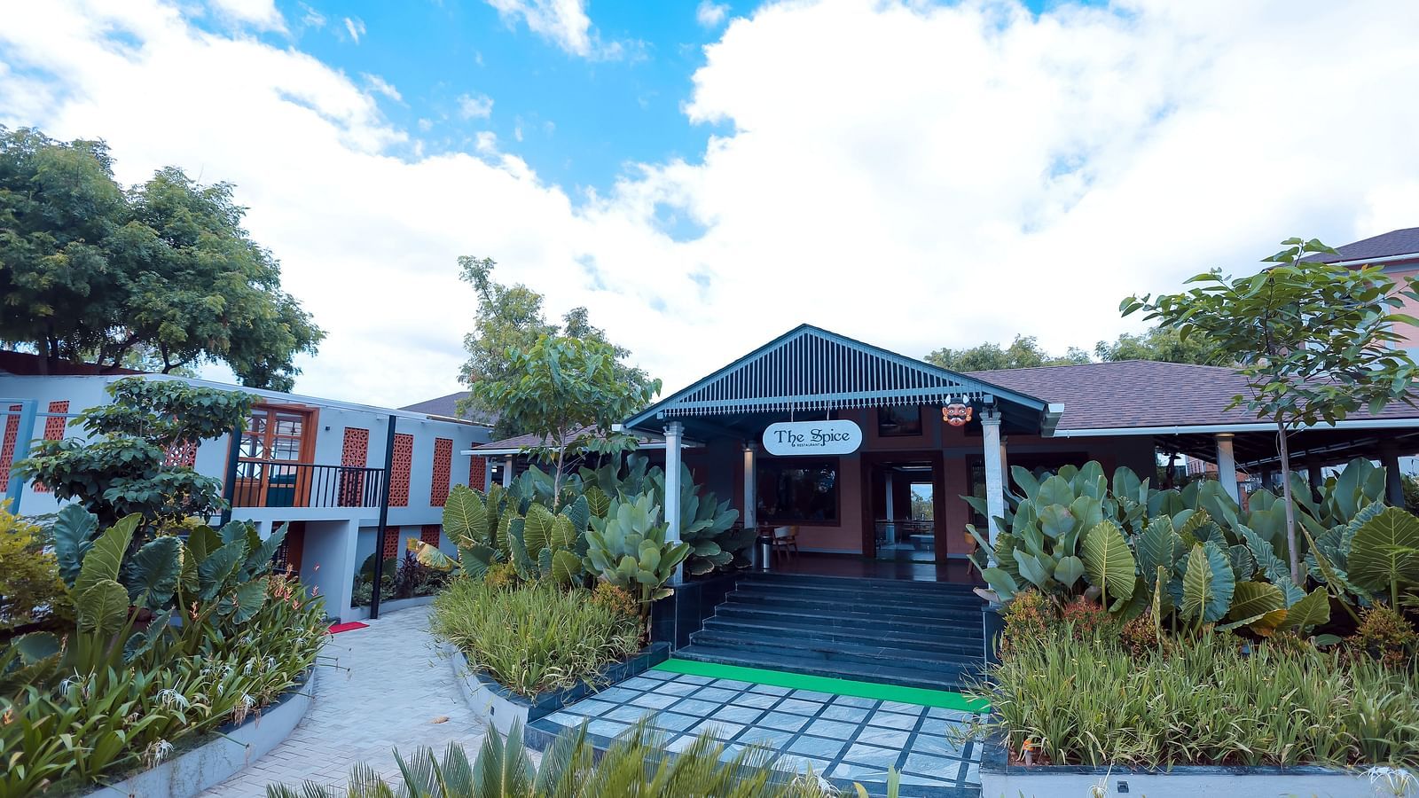 Garden entrance path with lush greenery leading to a villa at Trishvam Symphony, Krishnagiri.