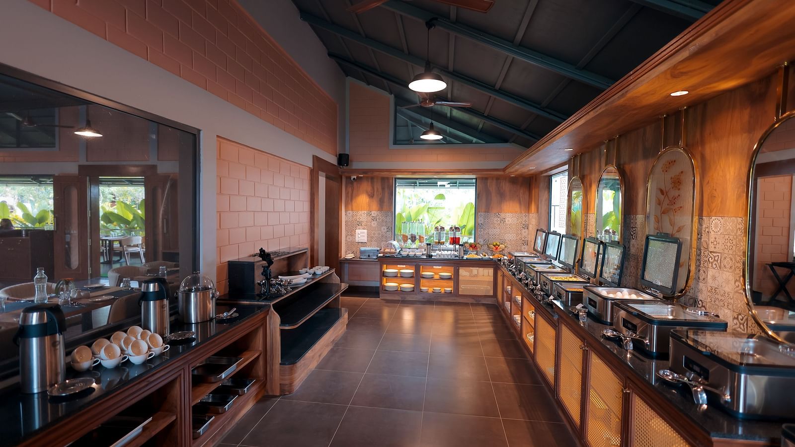Buffet counter in a rustic-themed dining hall with food warmers at Trishvam Symphony, Krishnagiri.