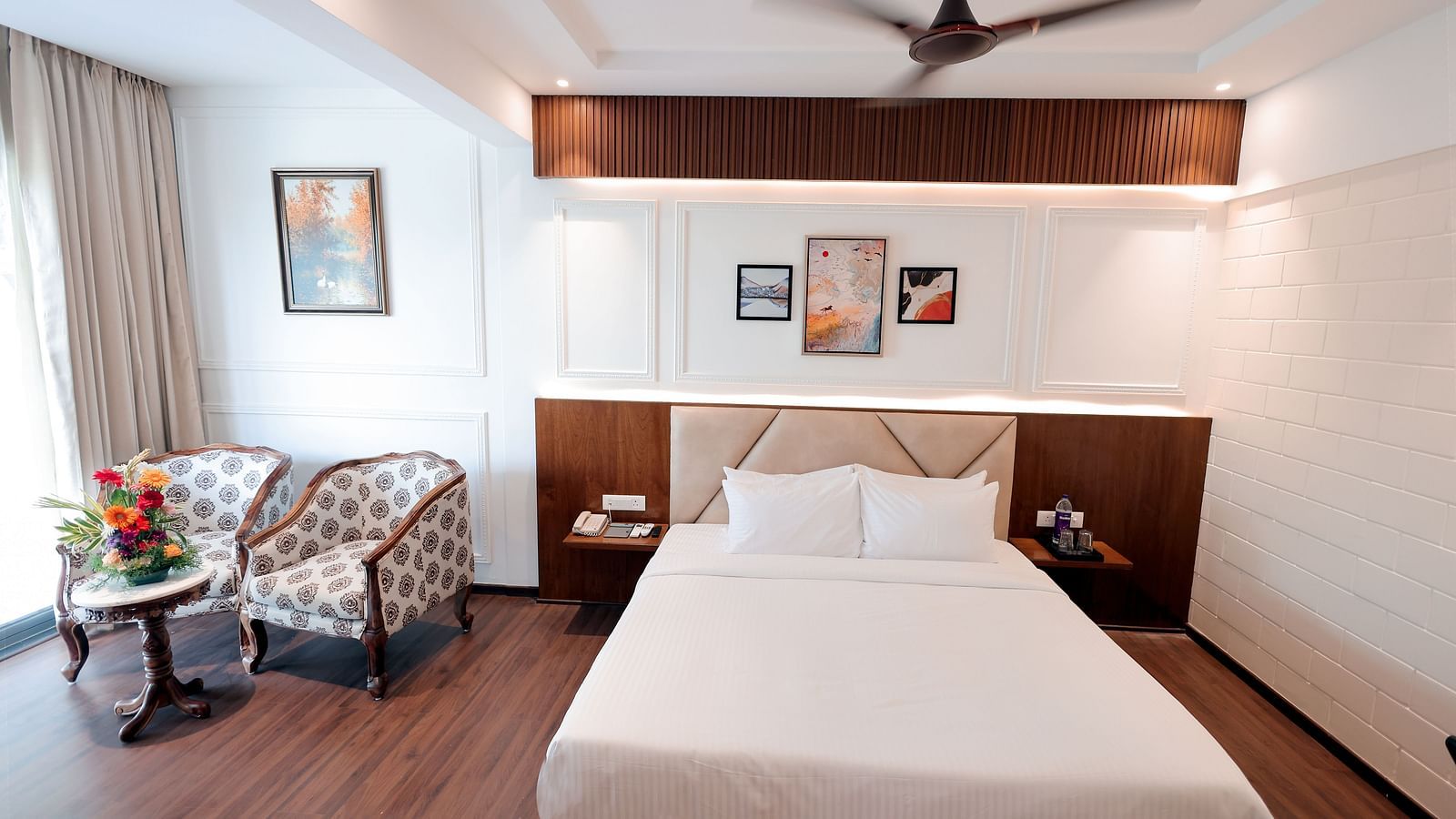 Neatly arranged bedroom with a double bed and modern furnishings at Trishvam Symphony, Krishnagiri.