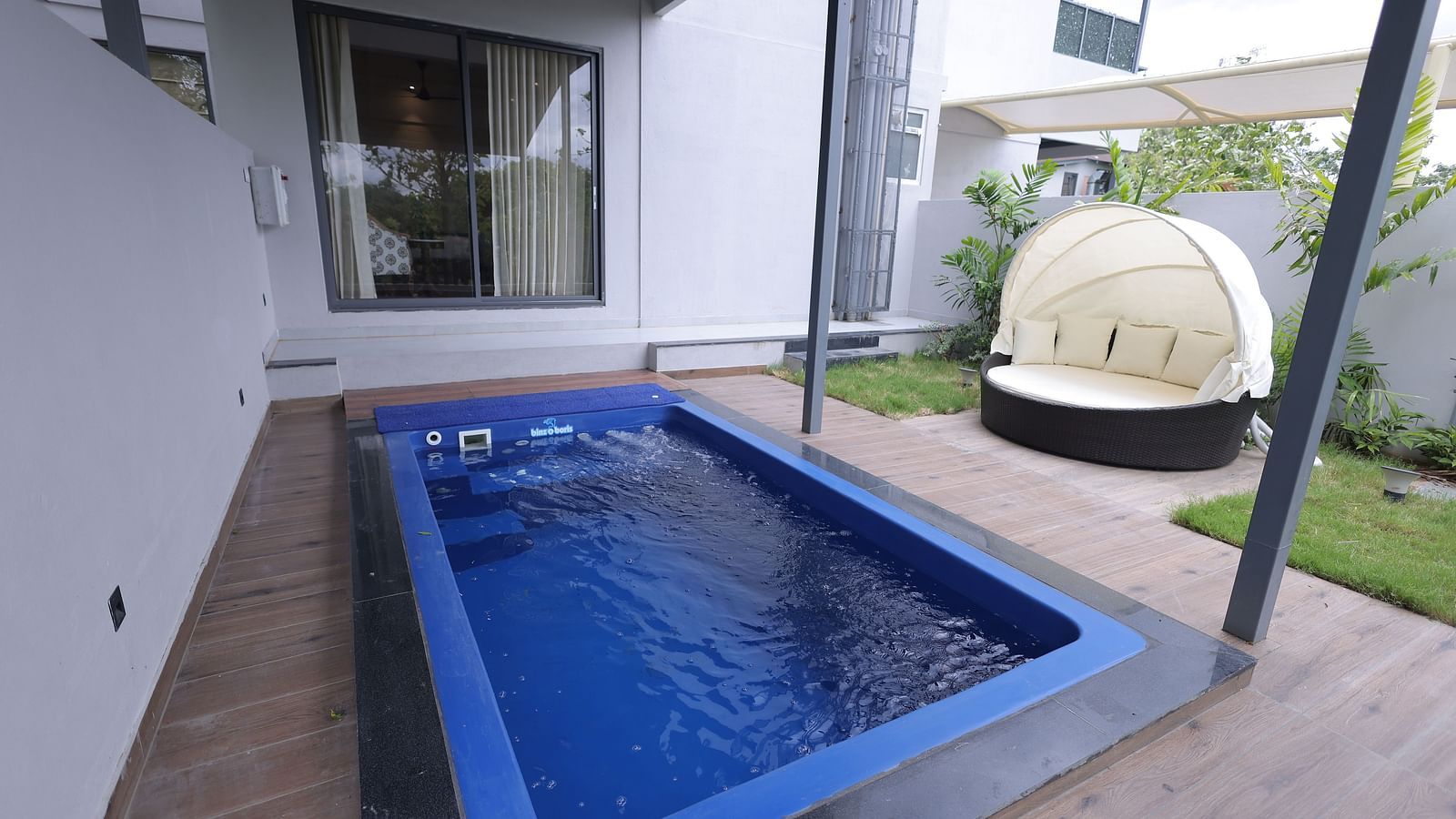  Private pool with canopy seating outside a modern villa at Trishvam Symphony, Krishnagiri.