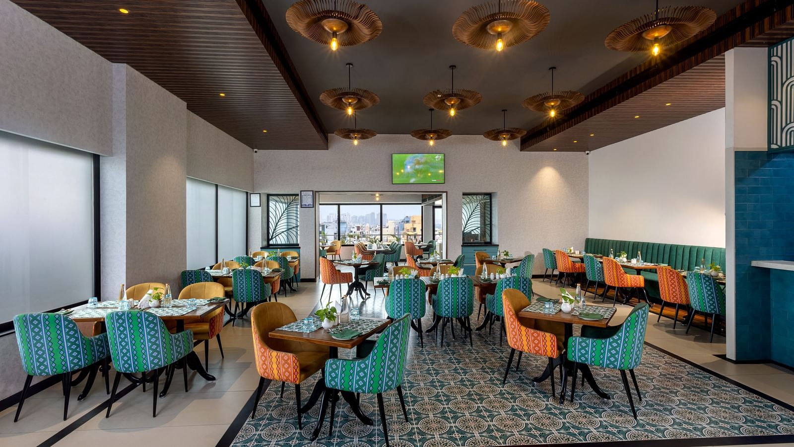 Spacious restaurant at Shalimar in Zibe Luxe Hyderabad by GRT Hotels offering a bright, city-facing setting with stylish ceiling lights.