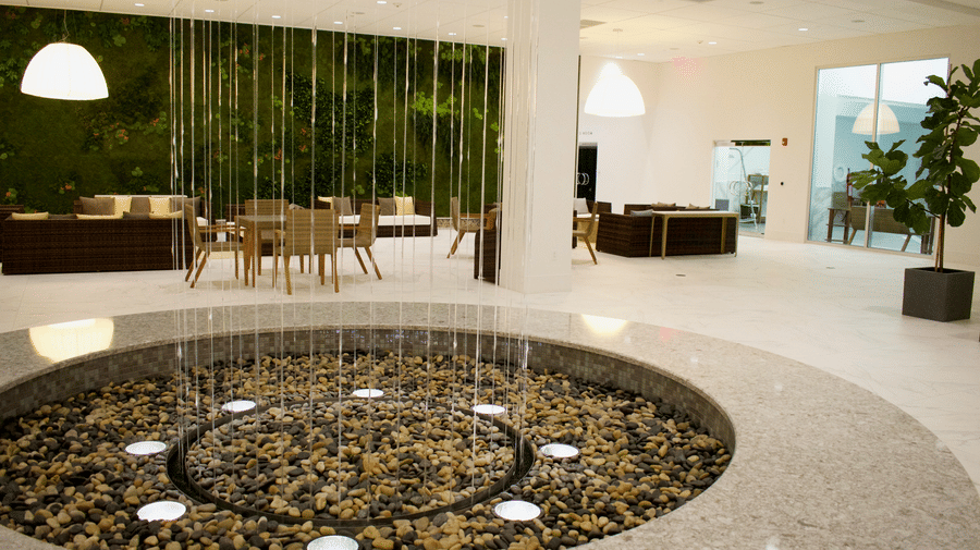 The lobby with a circular pebble water feature and a modern seating area with plants at YO1 Longevity & Health Resorts