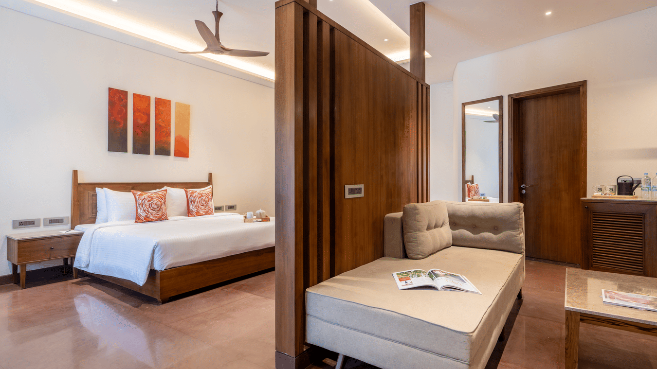 A bedroom with partition, on one side there is a bed and on the other there is a seating area with sofa and table at Ananta Spa and Resort, Ajabgarh