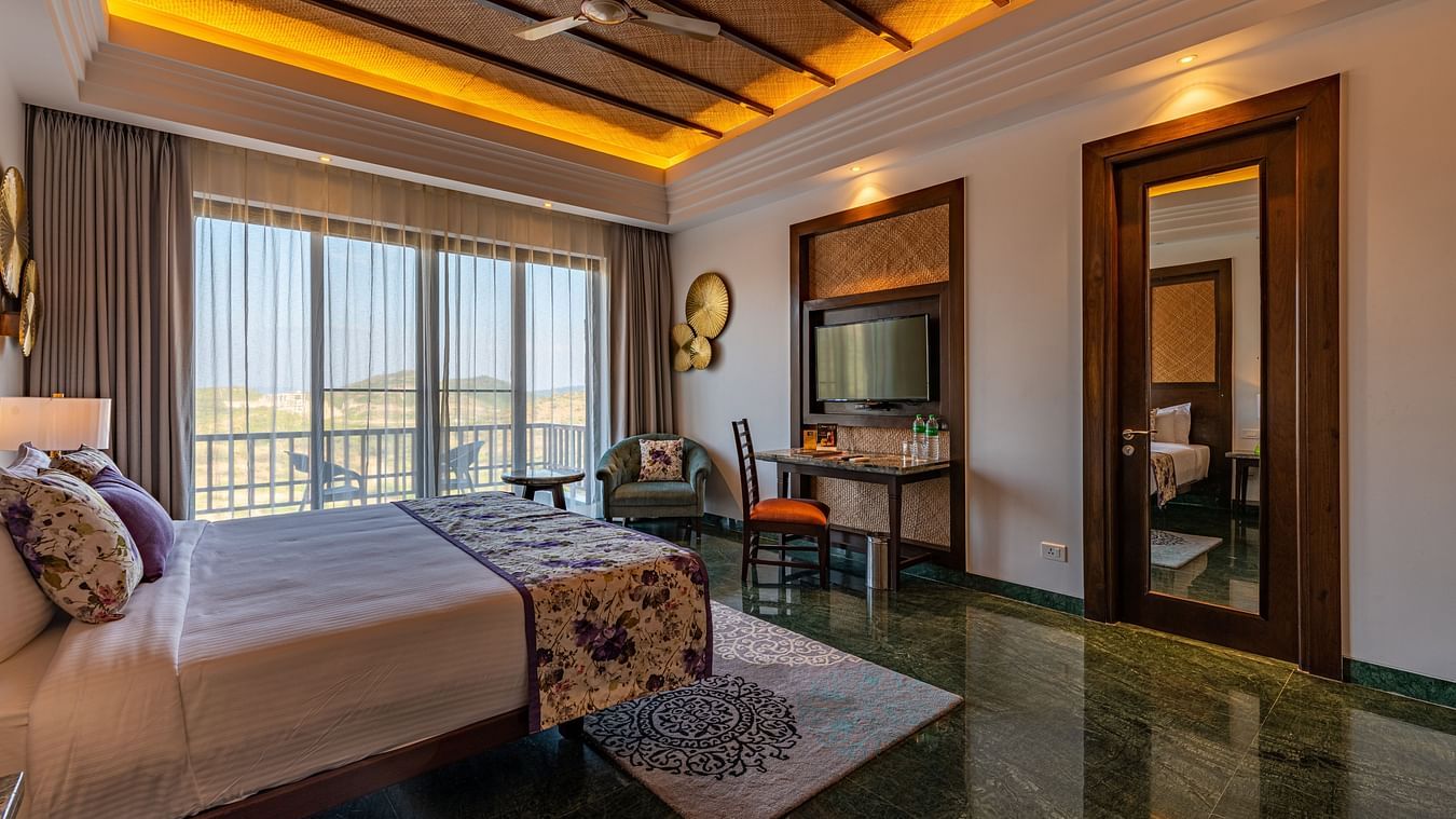 A king size bed, study table, big windows at luxury cottage with balcony - The Ananta Udaipur