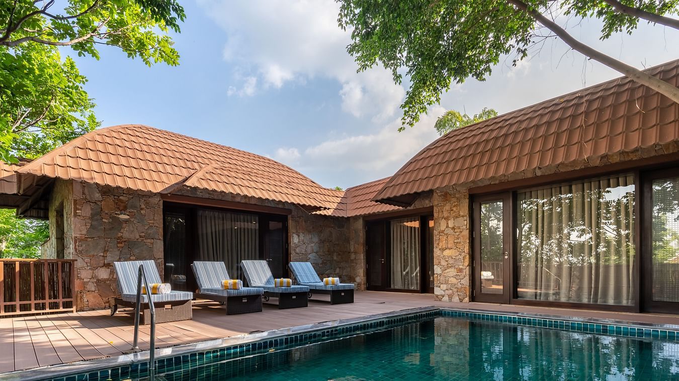 A swimming pool with lounge chairs in front of Ananta Villa - The Ananta Udaipur