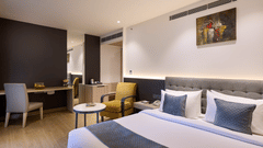 An image with a bed in the front and seating arrangement in the back