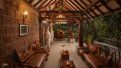 A reception area with terracotta tiles, stone walls, leather couches and warm lighting - Highland Sarovar Portico, Sindhudurg