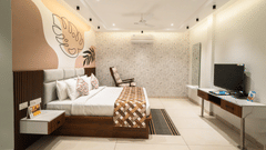 An image of a hotel bedroom with a large bed placed in front of a wall-mounted television - MGM Whispering Meadows