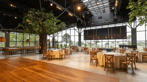 tables and chairs set up for an event in a banquet hall with floor to ceiling windows