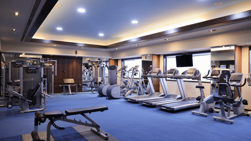 A well-equipped gym with various fitness machines, including treadmills and weight machines -  Balaji Sarovar Premiere, Solapur