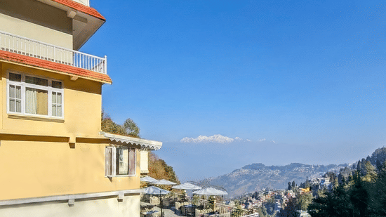 Side profile of the resort building overlooking a misty valley and distant mountains | Voyage Rodhi Resort