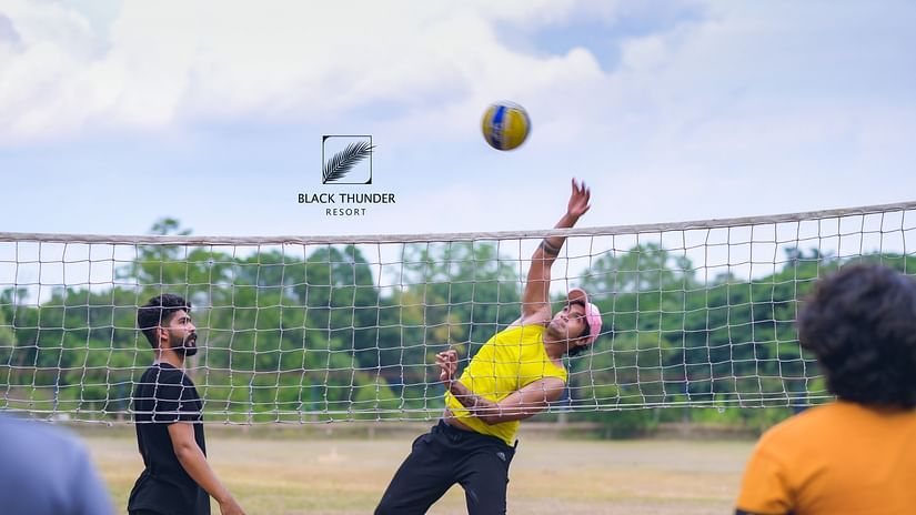 A group of people playing volleyball outdoors on a bright day - Black Thunder, Coimbatore