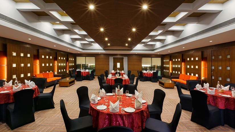 An overview of a banquet hall with circular tables with chairs arranged for an event - Heritage Village Resorts & Spa, Manesar.