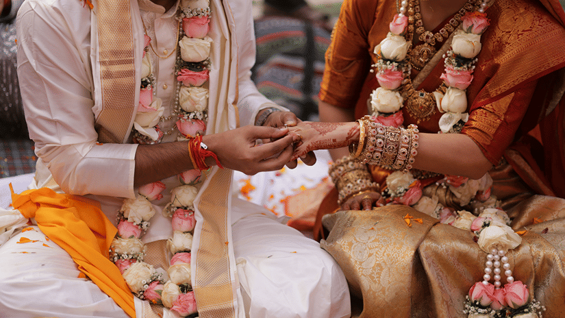 A groom putting a ring on the bride's finger