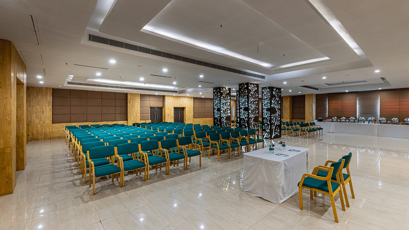 a banquet hall with green coloured seats kept in a theatre style setting 1