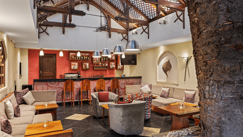 Casbah Bar lounge with sofas, armchairs and a bar counter under a high timber lattice roof