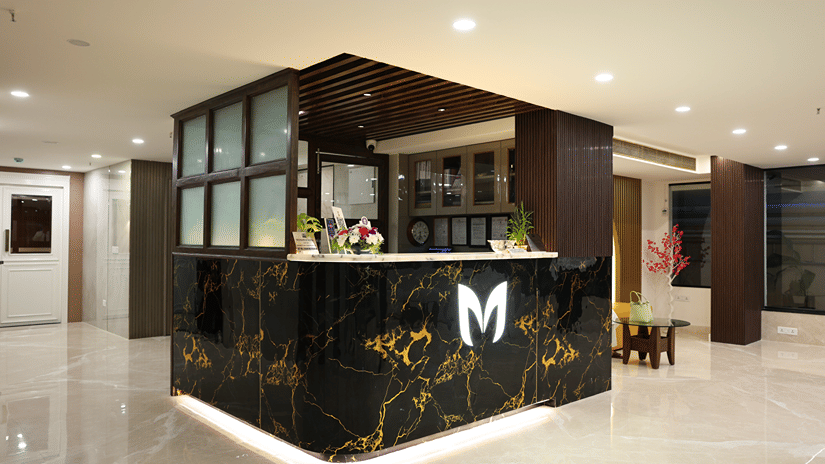 A hotel reception counter near Coronet Ball Room at The Monarch Hotel, Brigade Road with a front desk and lobby flooring.