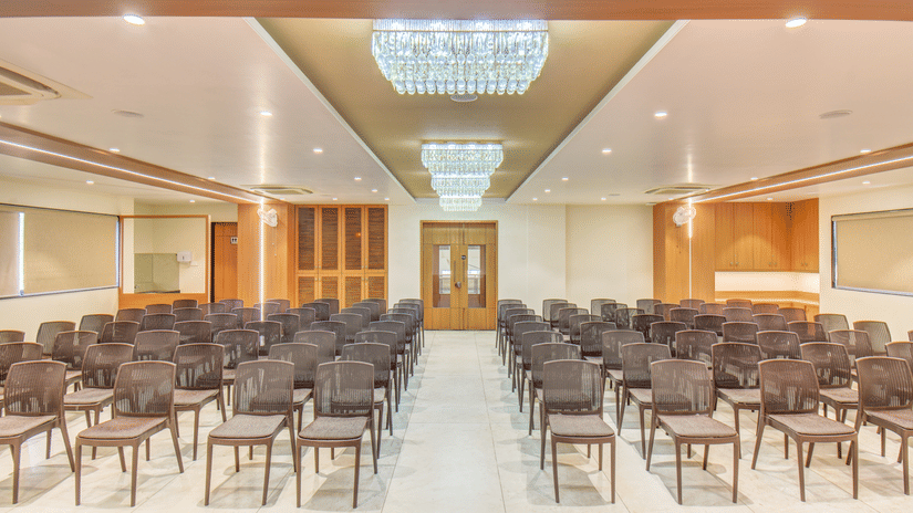 Ballroom at VITS Select Nashik Hotels & Resorts featuring chairs lined up under warm lighting and a door in the background.