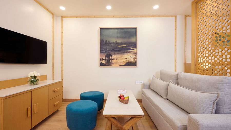 a sofa, a coffee table and a television in the living room of the Cottage at ABN Sarovar Portico, Jim Corbett