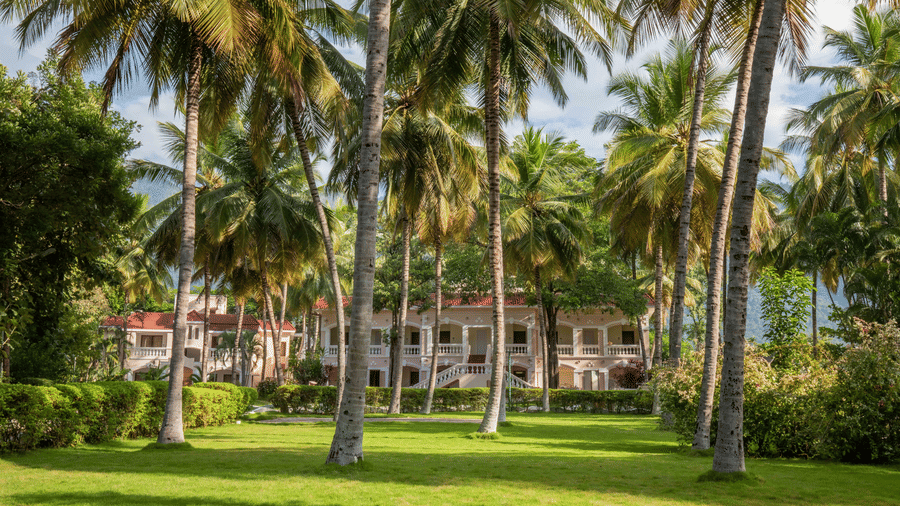 Scenic outdoor area with tall palm trees and lush green grass, leading to a distant building in a tropical setting - Black Thunder, Coimbatore