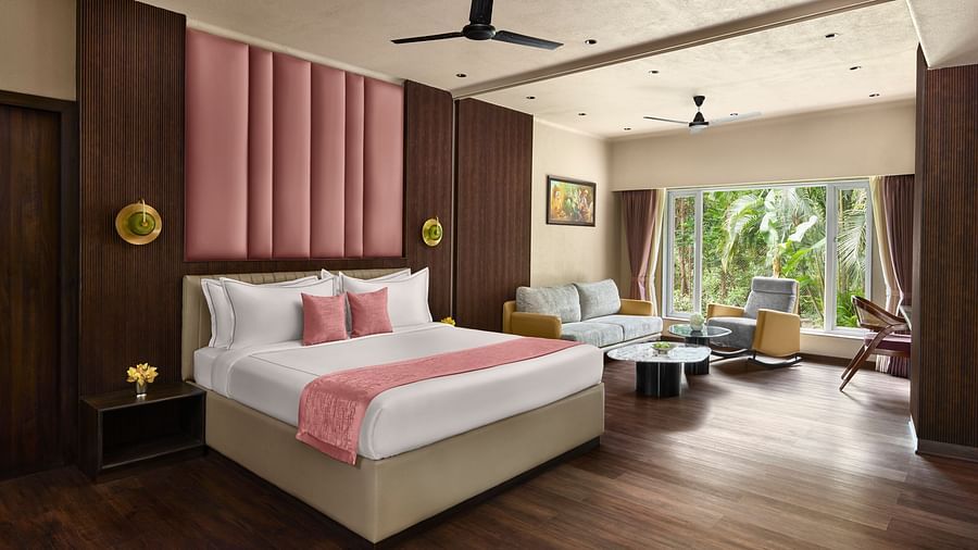 Junior Suite featuring a king size bed with a pink headboard and a spacious living area at DGV Resort by Treat, Silvassa.