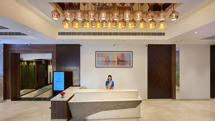 An image of the hotel reception with a woman standing behind the counter