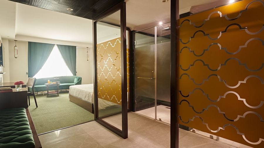 An image of a washroom with a transparent sliding door - Deventure Sarovar Portico, Patel Nagar