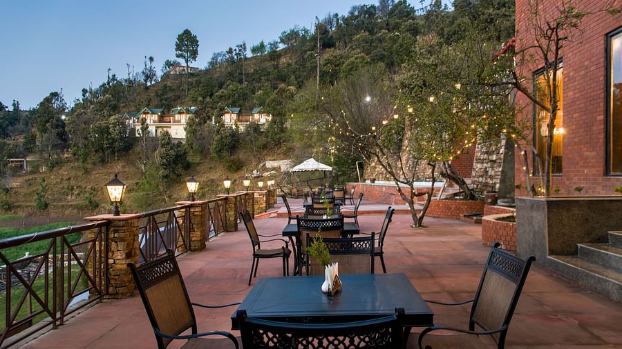  An inviting outdoor seating area at dusk, overlooking a stunning valley view, perfect for enjoying the peaceful ambiance and twilight scenery - Digantaa Resort in Mukteshwar
