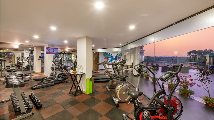 Well-equipped gym at Golden Tulip, Candolim, Goa, featuring treadmills, weights, and cycling machines in a spacious setting.