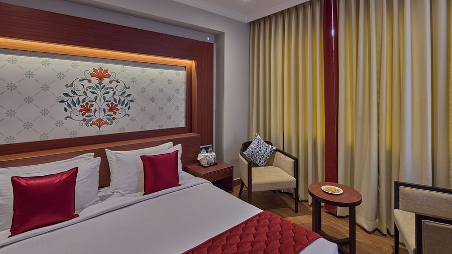 a king size bed with seats beside it - Golden Tulip, Tirupati 