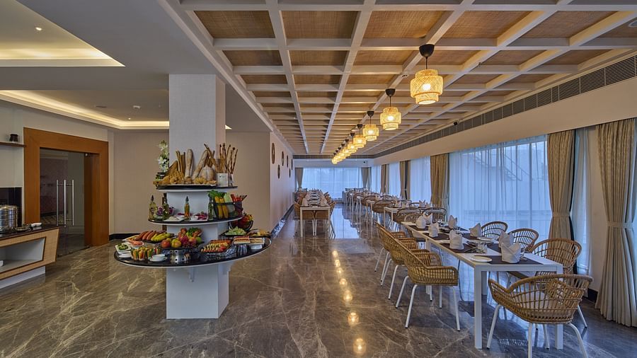 tables and chairs beside the buffet stations in Flavours, the all-day dining outlet at Grand Continent, Mahabalipuram