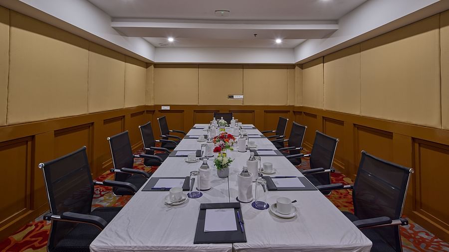 bottles, glasses, cups, and notepads on the table of the boardroom at Grand Continent, Mahabalipuram
