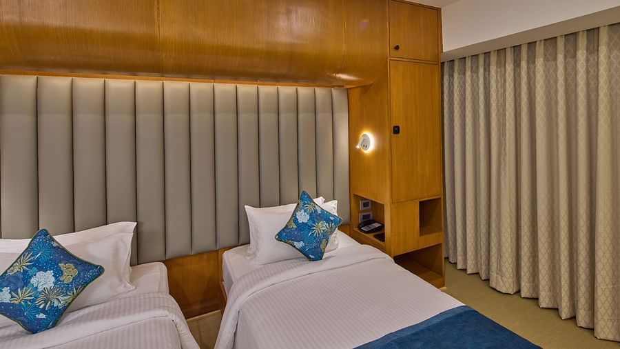 twin beds and a nightstand in The Grand Canal Twin room at Grand Continent, Mahabalipuram