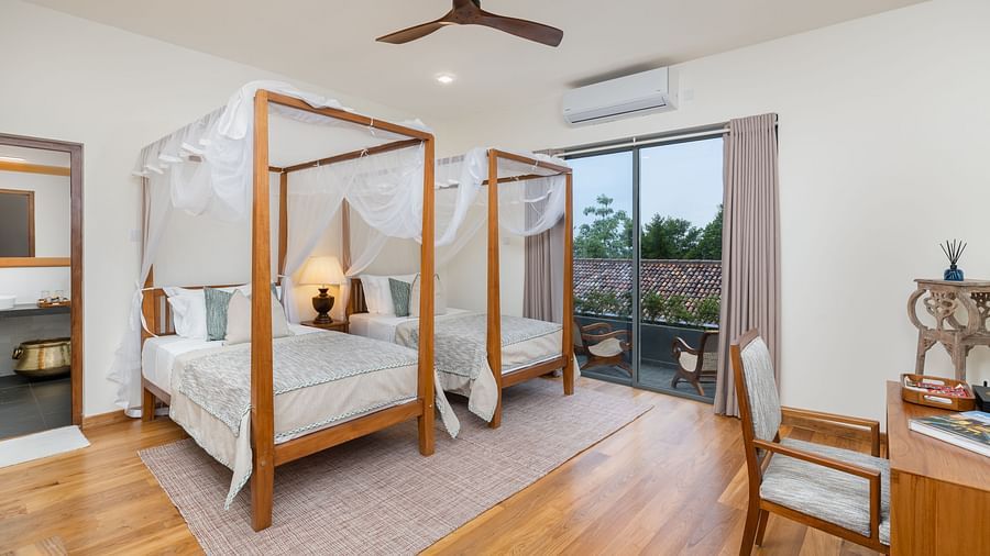 A well-lit room with twin canopy beds, elegant decor, and a spacious layout - Deluxe Room at Heavensa Villas and Suites by the Clarks, Galle