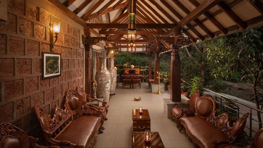 A reception area with terracotta tiles, stone walls, leather couches and warm lighting - Highland Sarovar Portico, Sindhudurg