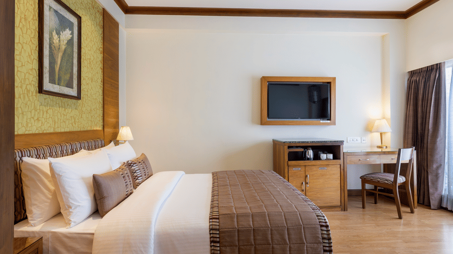 Business Club Room with a bed, work desk and wall mounted television at Kenilworth Hotel, Kolkata.