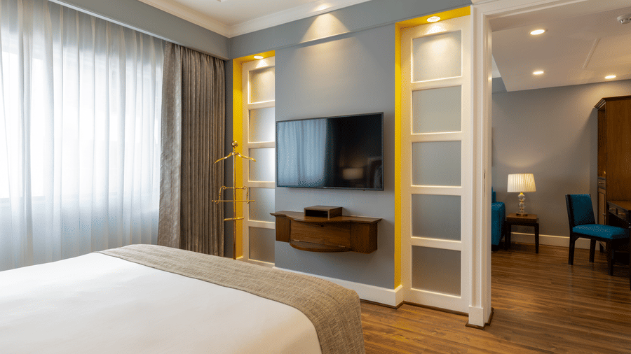 Junior Suite with a bed, television and separate lounge seating at Kenilworth Hotel, Kolkata.