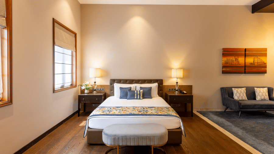 Premier Club Suite with a bed, framed artwork and lounge seating at Kenilworth Hotel, Kolkata.