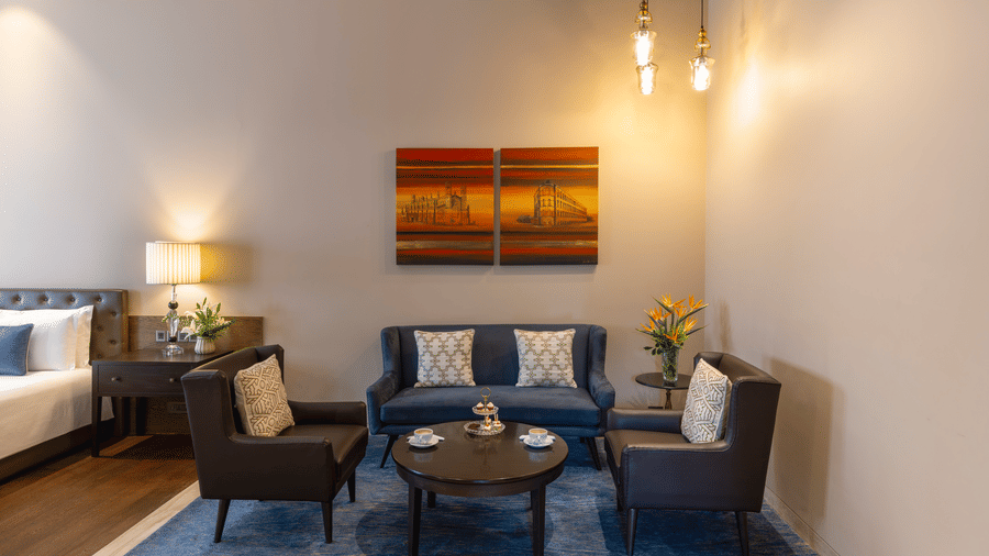 Premier Club Suite lounge area with armchairs and a round coffee table at Kenilworth Hotel, Kolkata.