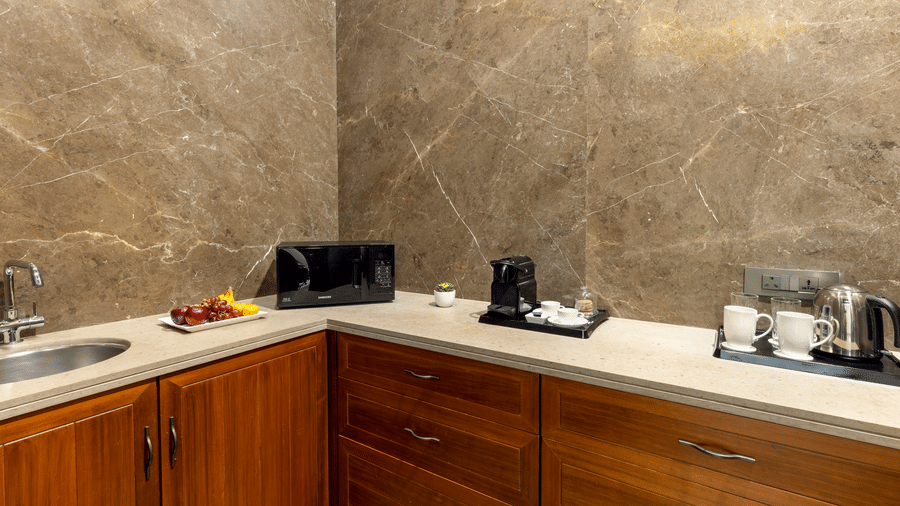 Presidential Suite kitchenette with a countertop, sink and coffee maker at Kenilworth Hotel, Kolkata.