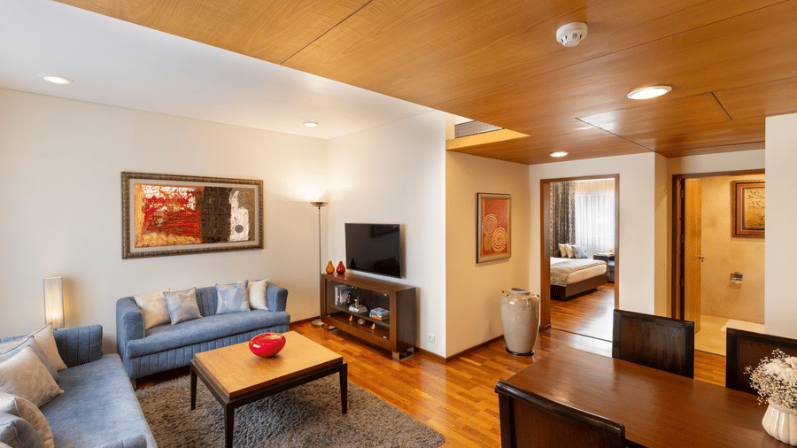 Russel Suite lounge area with a sofa and cabinet in wood panelled interiors at Kenilworth Hotel, Kolkata.