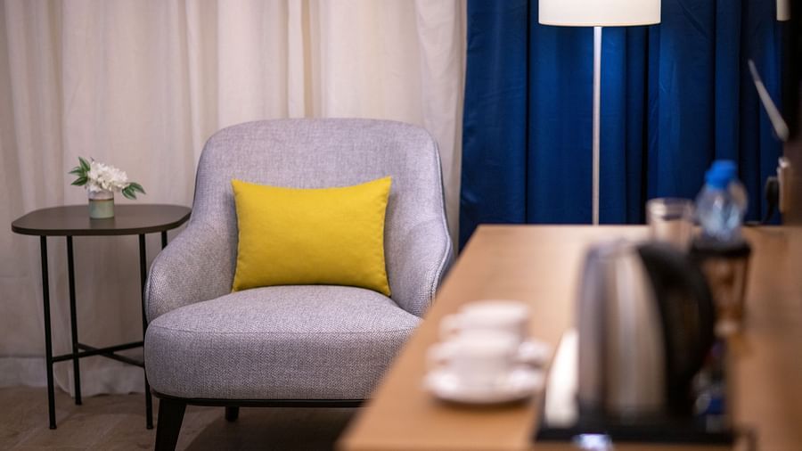 a Sofa in the background with a lamp next to it inside one of the rooms - La Maison Hotel, Doha