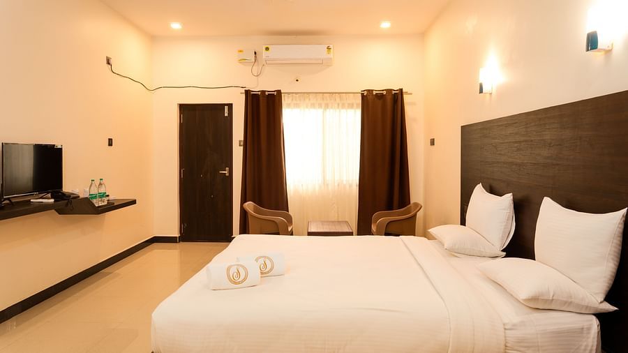 A double bed with a tv opposite it inside standard ac room - Mastiff Select Terrain