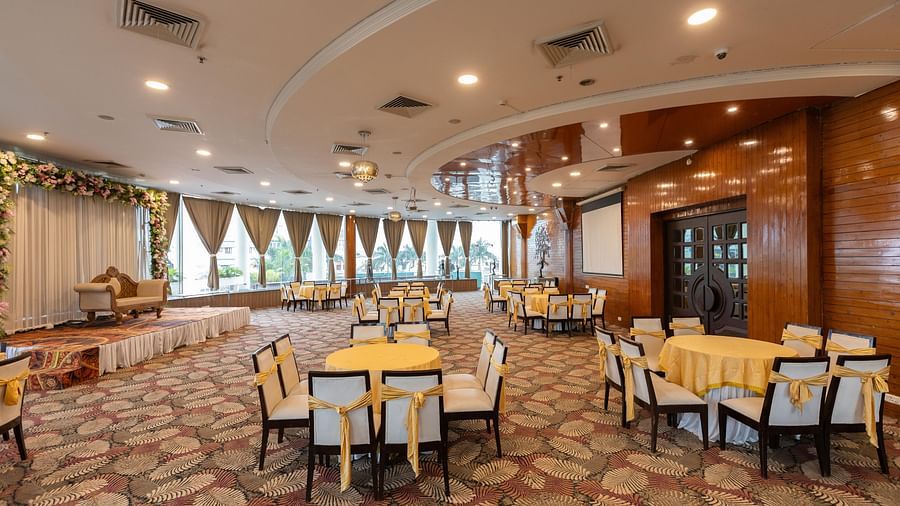  A large banquet hall or event space with multiple round tables set for a function - Pride Premier Dehradun