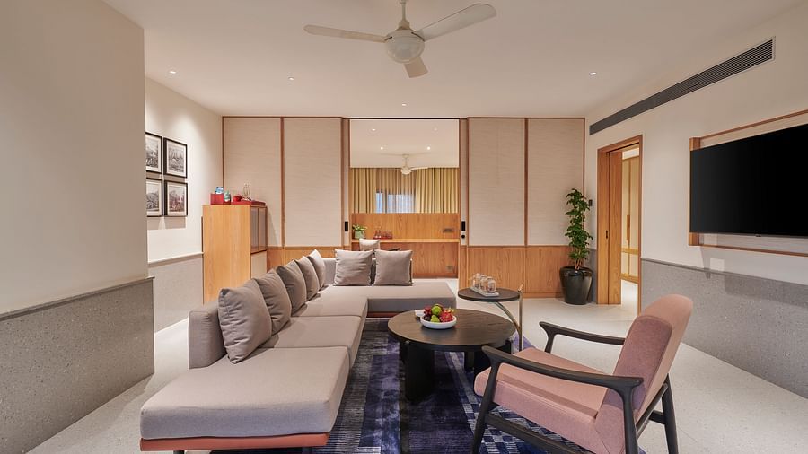 A living room with an arm chair and sofa surrounding a small round table on a  carpet and a TV at The Dukes Retreat.