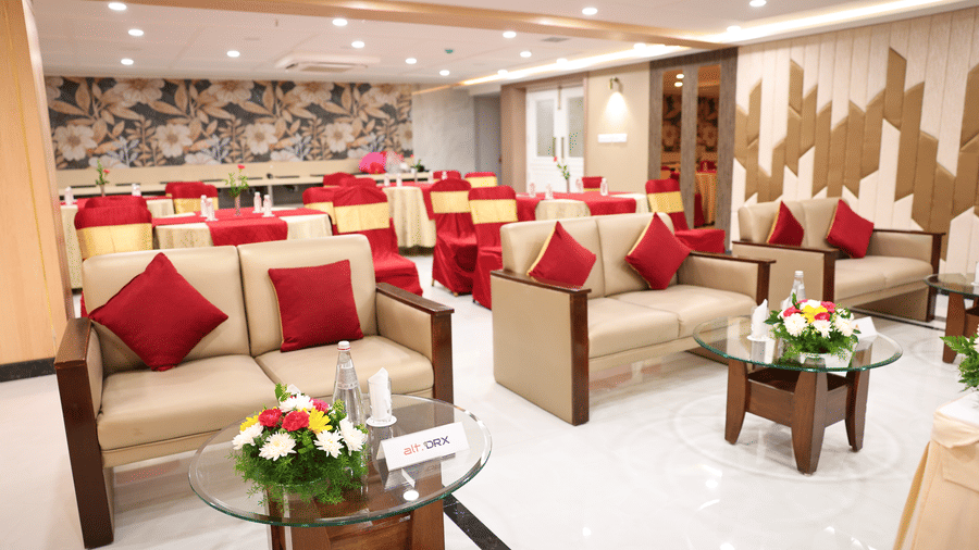 A lounge-style seating arrangement with sofas, centre tables, and floral accents inside the Coronet Ballroom at Monarch Hotel, Brigade Road.