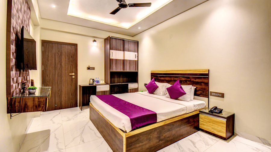 Super Deluxe Room wide view with king bed, wardrobe, TV and marble flooring at VITS Select Kharadi Pune